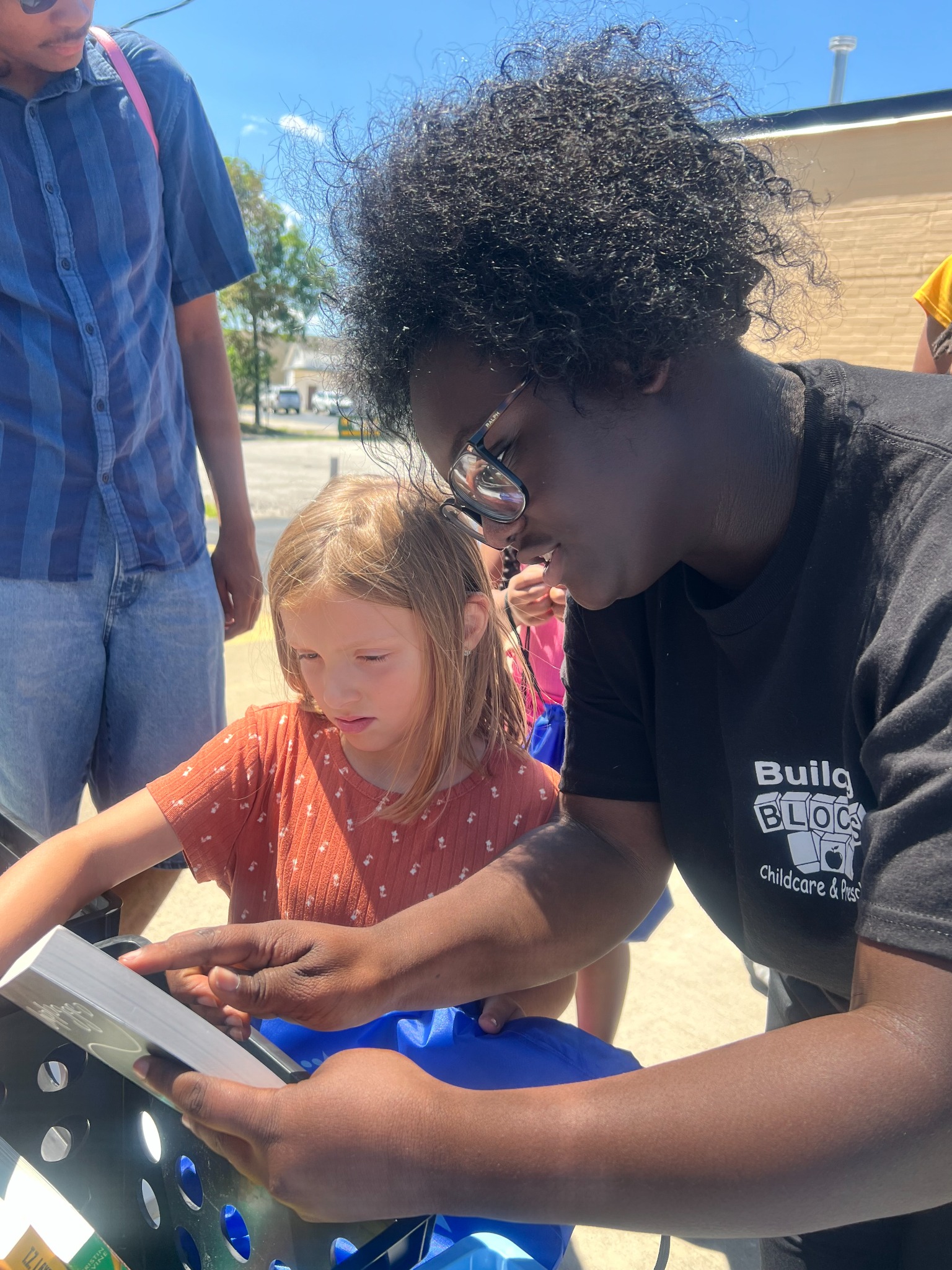 A Building Blocks team member helping a child choose a book